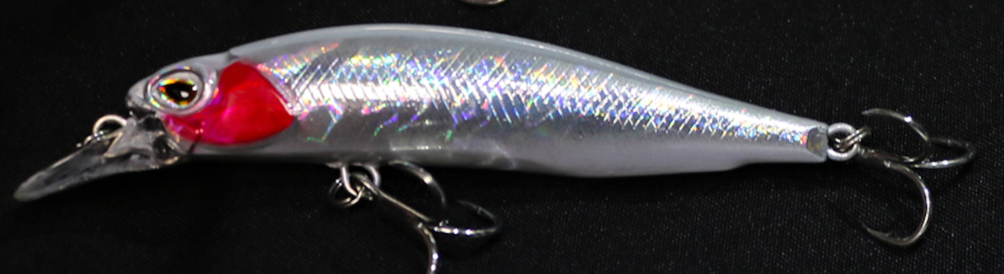 Fishing lure with a red and white design on a black background